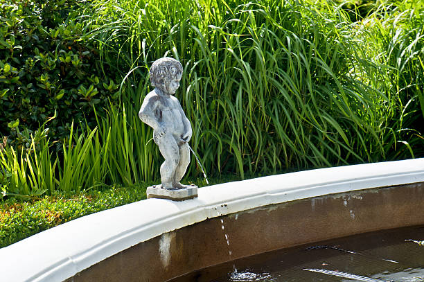 "A comical statue of a small boy, water feature/fountain uurinating into a walled garden pond."